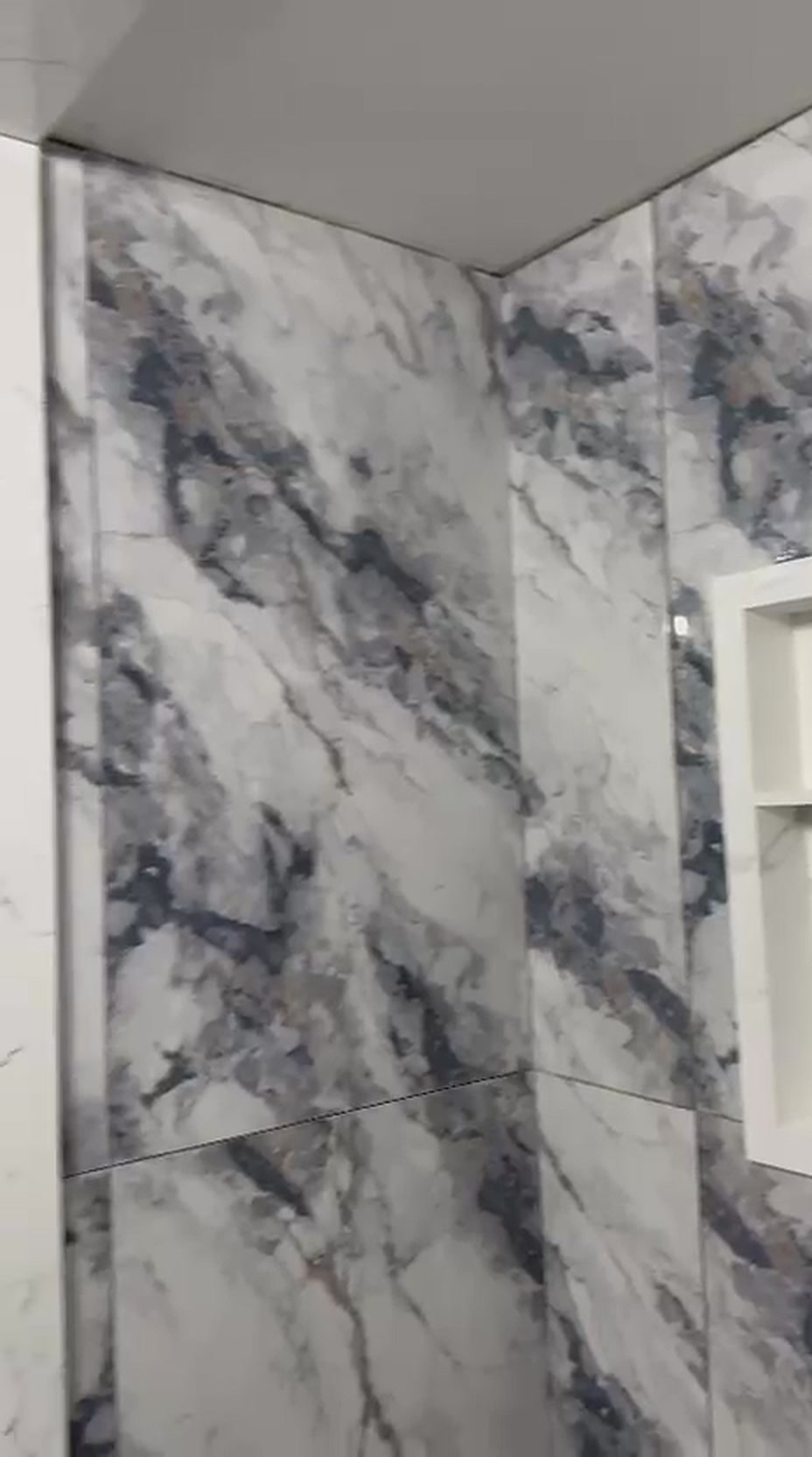 Vaughan bathroom renovation with diagonally veined large-format marble tile running seamlessly across two shower walls